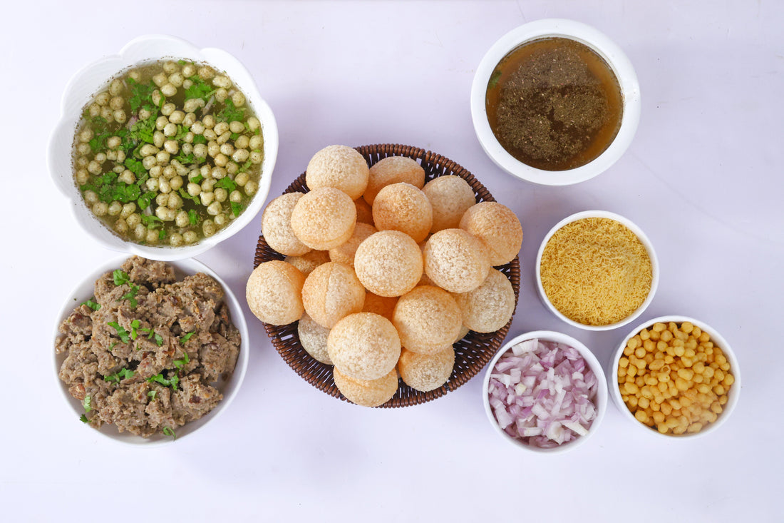 Indian street food pani puri with crispy puris, flavored water, boiled chickpeas, onions, and spiced mashed filling